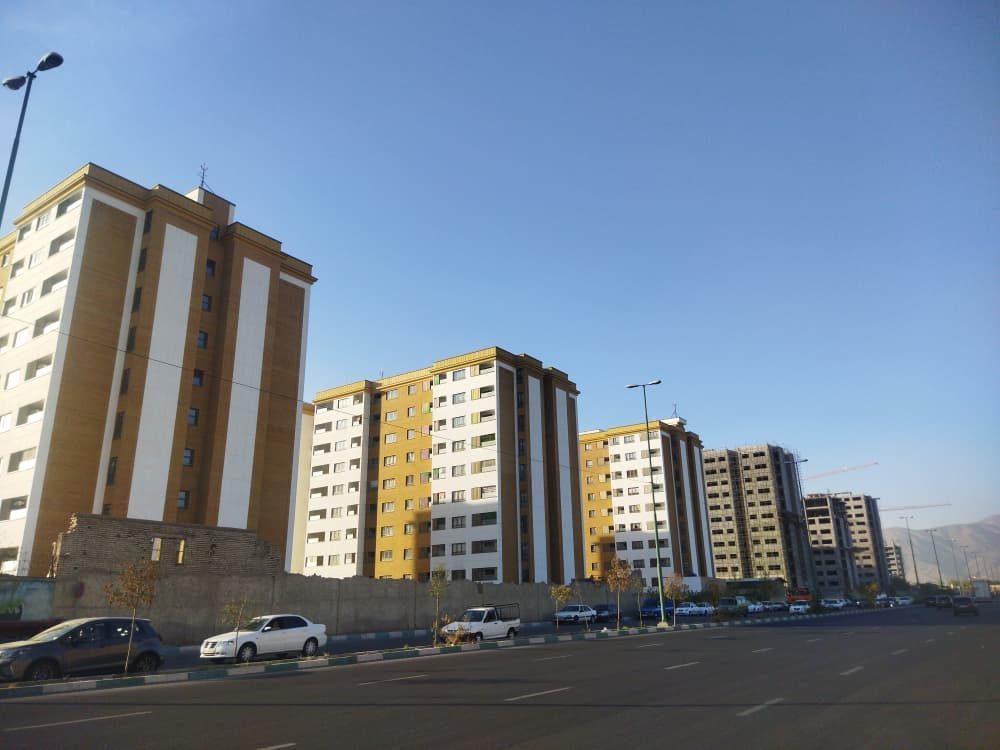 ردیف بلوکهای تکمیلشده با نمای سفید و خردلی زیر آسمان آبی